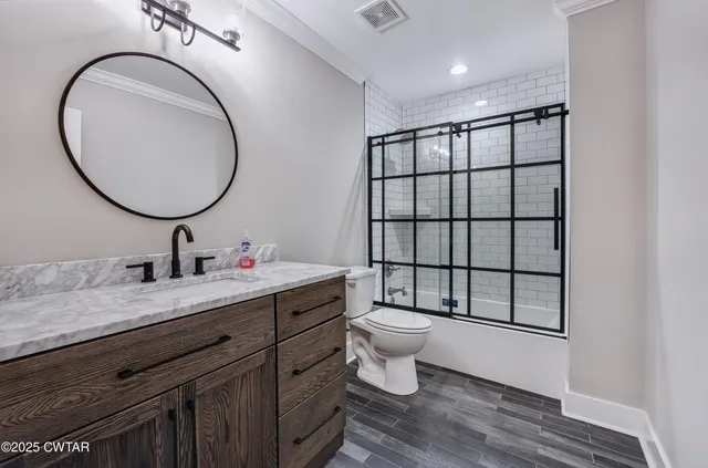 a bathroom with a toilet a sink a mirror and a window