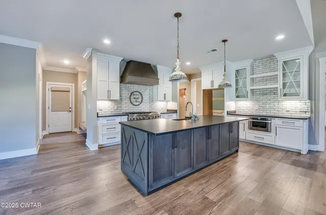 a kitchen with stainless steel appliances kitchen island a large counter space and wooden floor