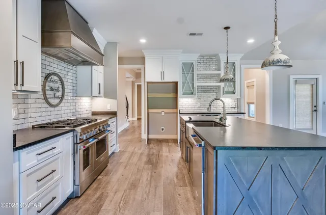 a kitchen with stainless steel appliances granite countertop a sink stove and refrigerator