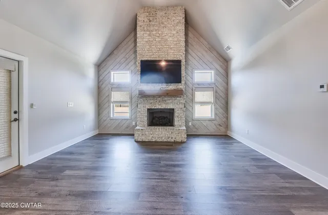 a view of an empty room with exposed radiator and fireplace