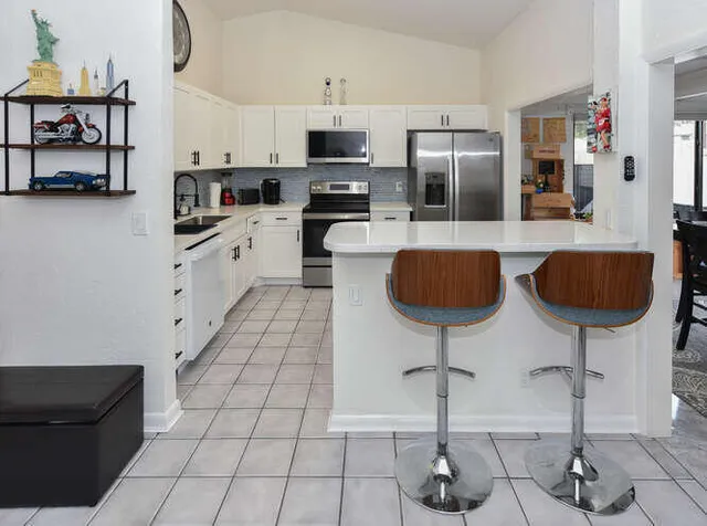 a kitchen with kitchen island granite countertop a sink a stove and refrigerator