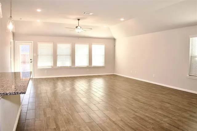 an empty room with a ceiling fan and a window