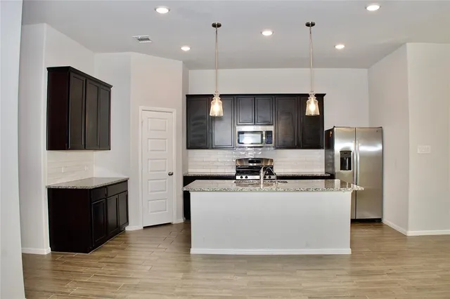 a view of kitchen with granite countertop cabinets and sink