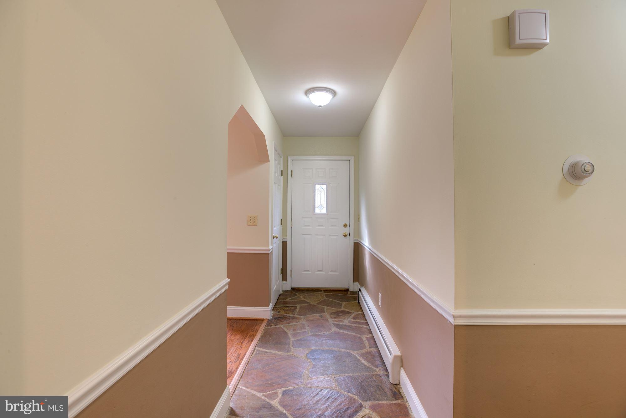 8203 Frye Road Alexandria, VA 22309 - Photo 6 of 34 Stone tiled front hall looking at front door
