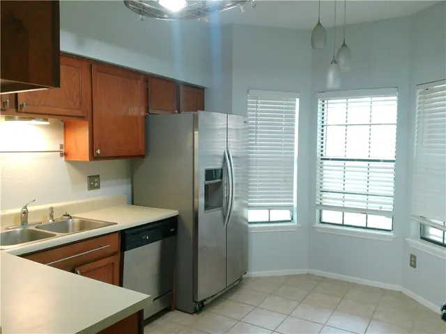 a kitchen with a sink a refrigerator and window