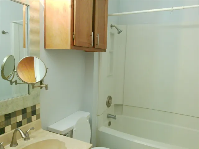 a bathroom with a sink mirror vanity and toilet