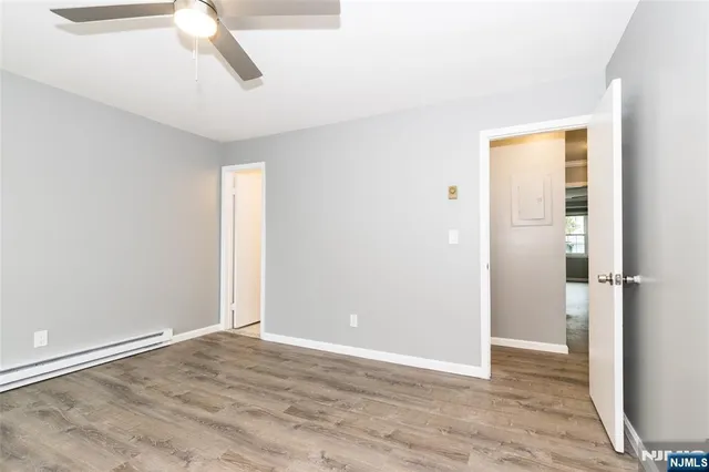 a view of empty room with wooden floor