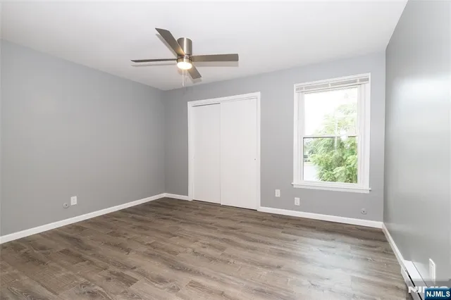 an empty room with a window and ceiling fan