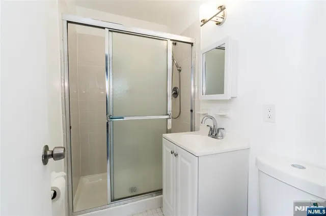 a bathroom with a sink mirror and shower