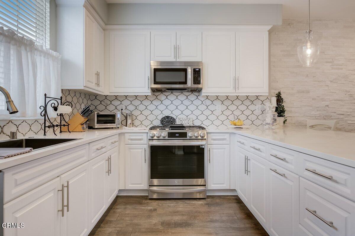 3654 Islander Walk Oxnard, CA 93035 - Photo 20 of 61 a kitchen with white cabinets and stainless steel appliances