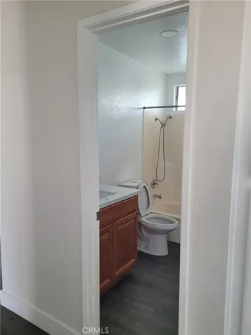 a bathroom with a granite countertop sink a toilet and shower