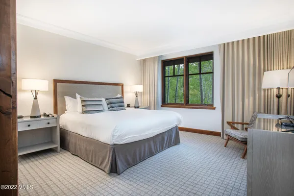 a bedroom with a large bed and a lamp on table