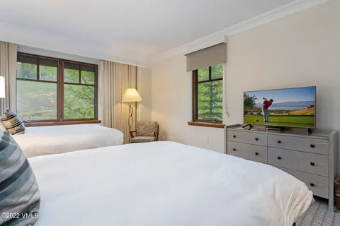 a bedroom with a bed and a dresser next to a window