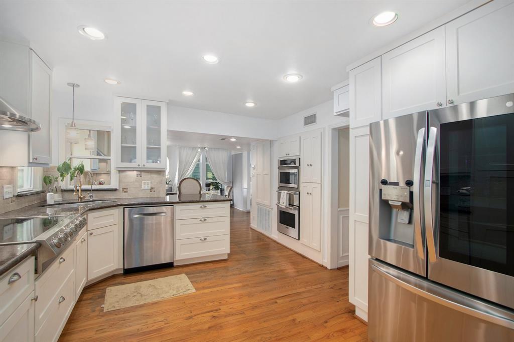a large kitchen with stainless steel appliances a refrigerator and a sink
