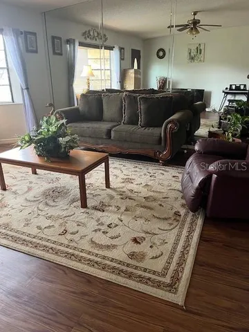 a living room with furniture and a wooden floor
