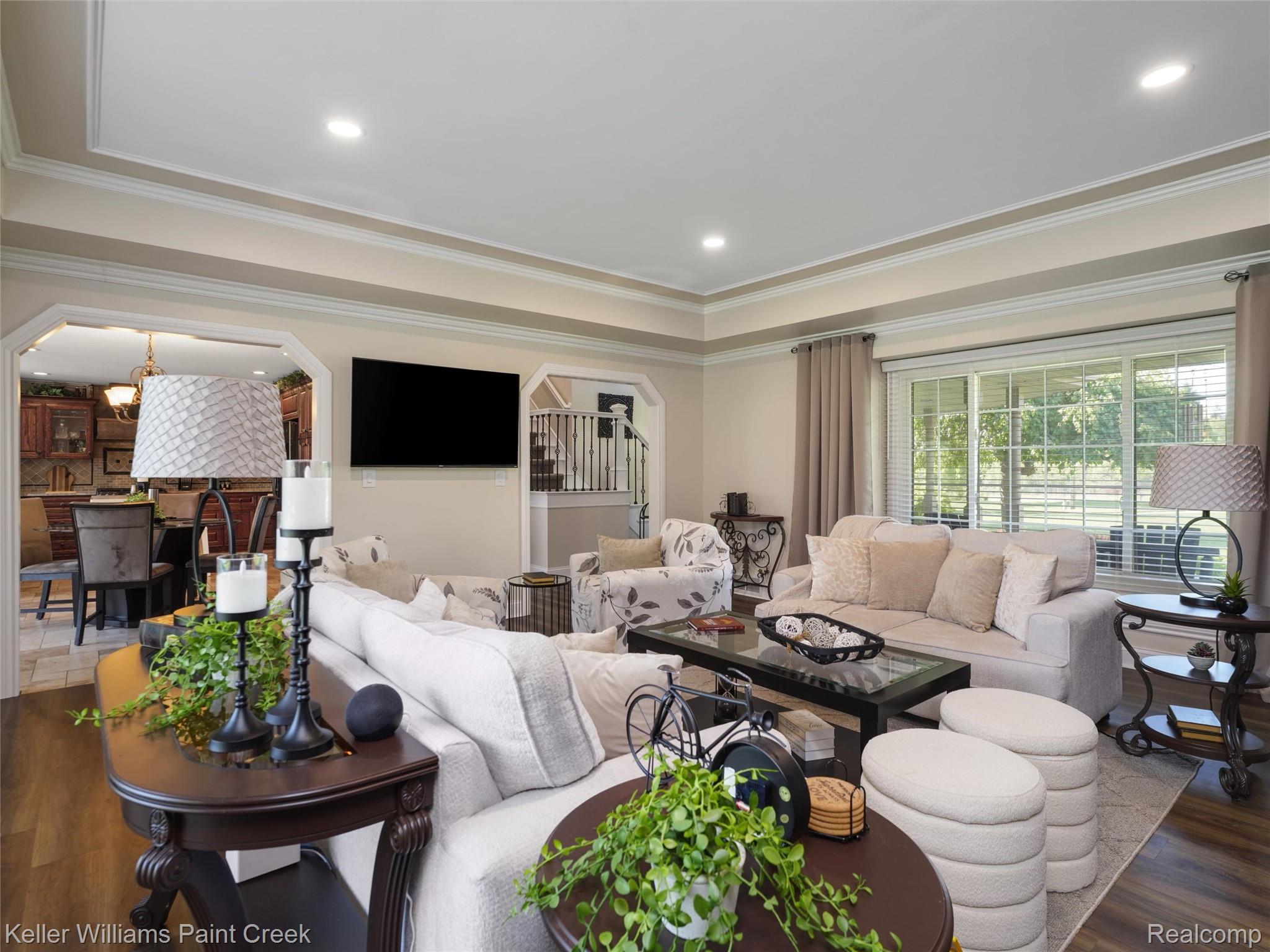 5813 36 Mile Road Romeo, MI 48065 - Photo 5 of 81 Spacious living area featuring wood-finish flooring, a tray ceiling with recessed lighting, and large windows with horizontal blinds