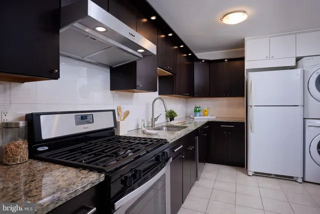 a kitchen with stainless steel appliances granite countertop a refrigerator and a stove top oven