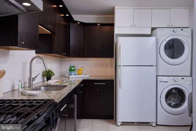 a kitchen with stainless steel appliances granite countertop a sink a stove and a refrigerator