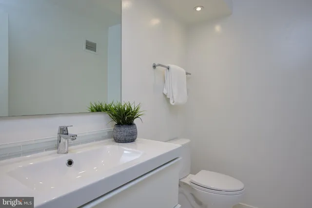 a bathroom with a sink a toilet and mirror