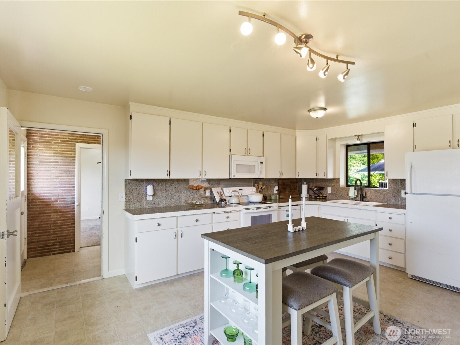 1417 Maple Street Sumner, WA 98390 - Photo 30 of 40 a kitchen with a sink a stove a refrigerator and white cabinets
