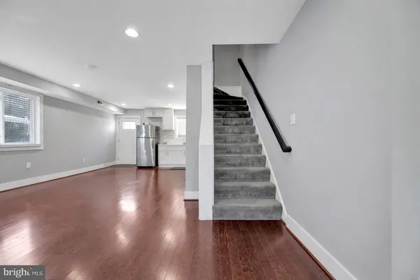 a view of a hallway with wooden floor and staircase