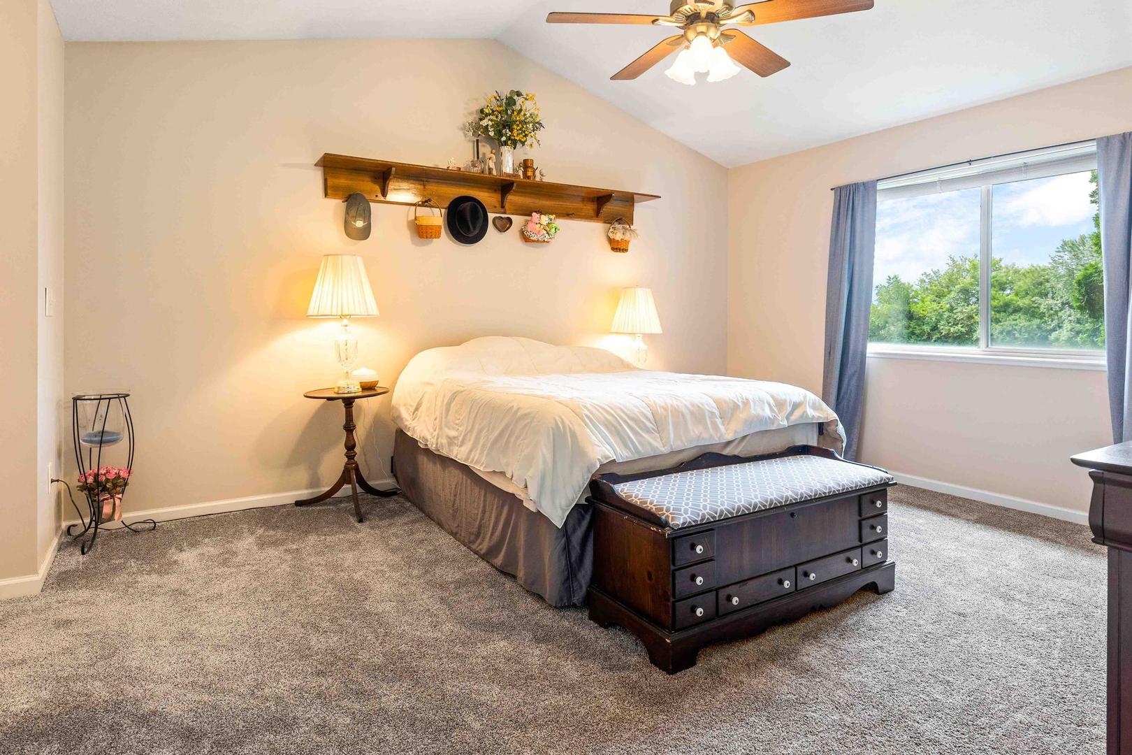 107 Labrador Lane Downs, IL 61736 - Photo 15 of 35 a spacious bedroom with a bed and a chandelier