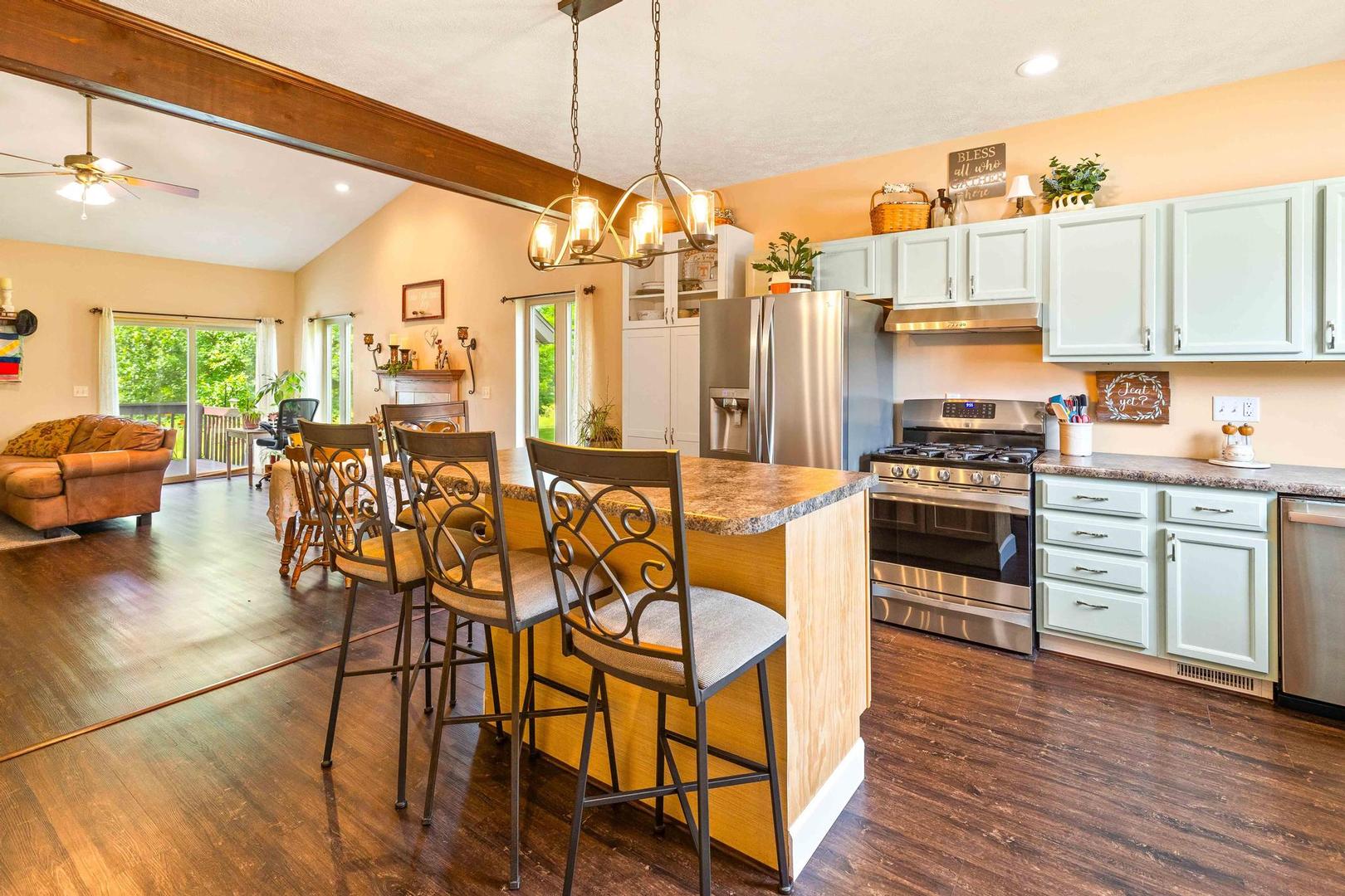 107 Labrador Lane Downs, IL 61736 - Photo 6 of 35 a kitchen with stainless steel appliances kitchen island granite countertop a dining table chairs stove and sink