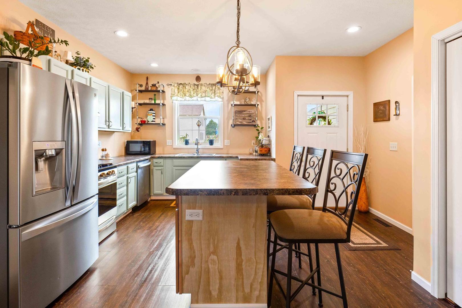 107 Labrador Lane Downs, IL 61736 - Photo 10 of 35 a kitchen with stainless steel appliances granite countertop a refrigerator a stove top oven a sink dishwasher and white cabinets with wooden floor