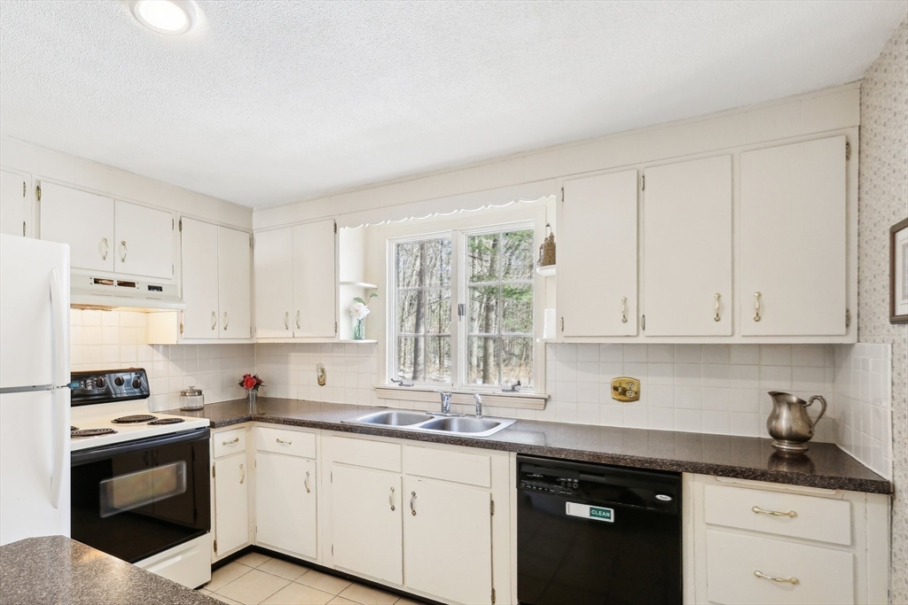 17 Wedgewood Road Stow, MA 01775 - Photo 8 of 31 a kitchen with granite countertop white cabinets and stainless steel appliances
