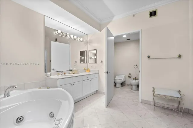 a spacious bathroom with a tub sink and mirror