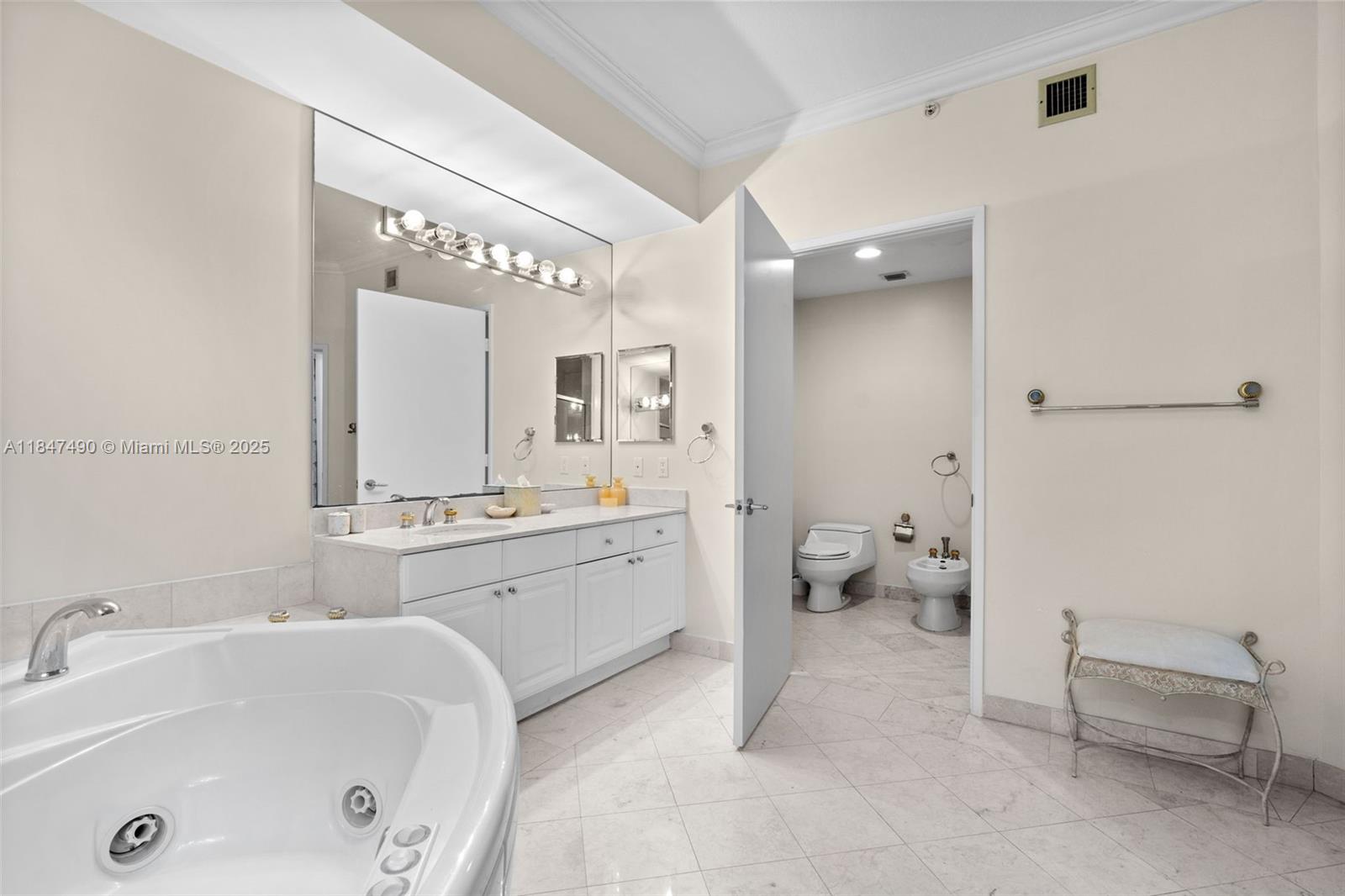 733 Crandon Boulevard, Unit 405 Key Biscayne, FL 33149 - Photo 14 of 42 a spacious bathroom with a tub sink and mirror