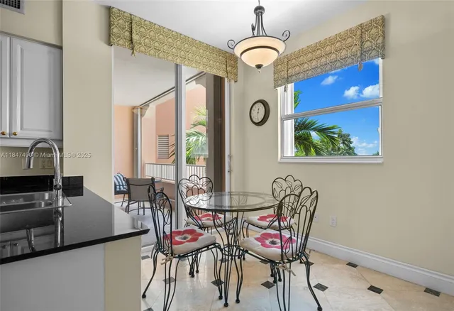 a view of a dining room with furniture a chandelier and a window