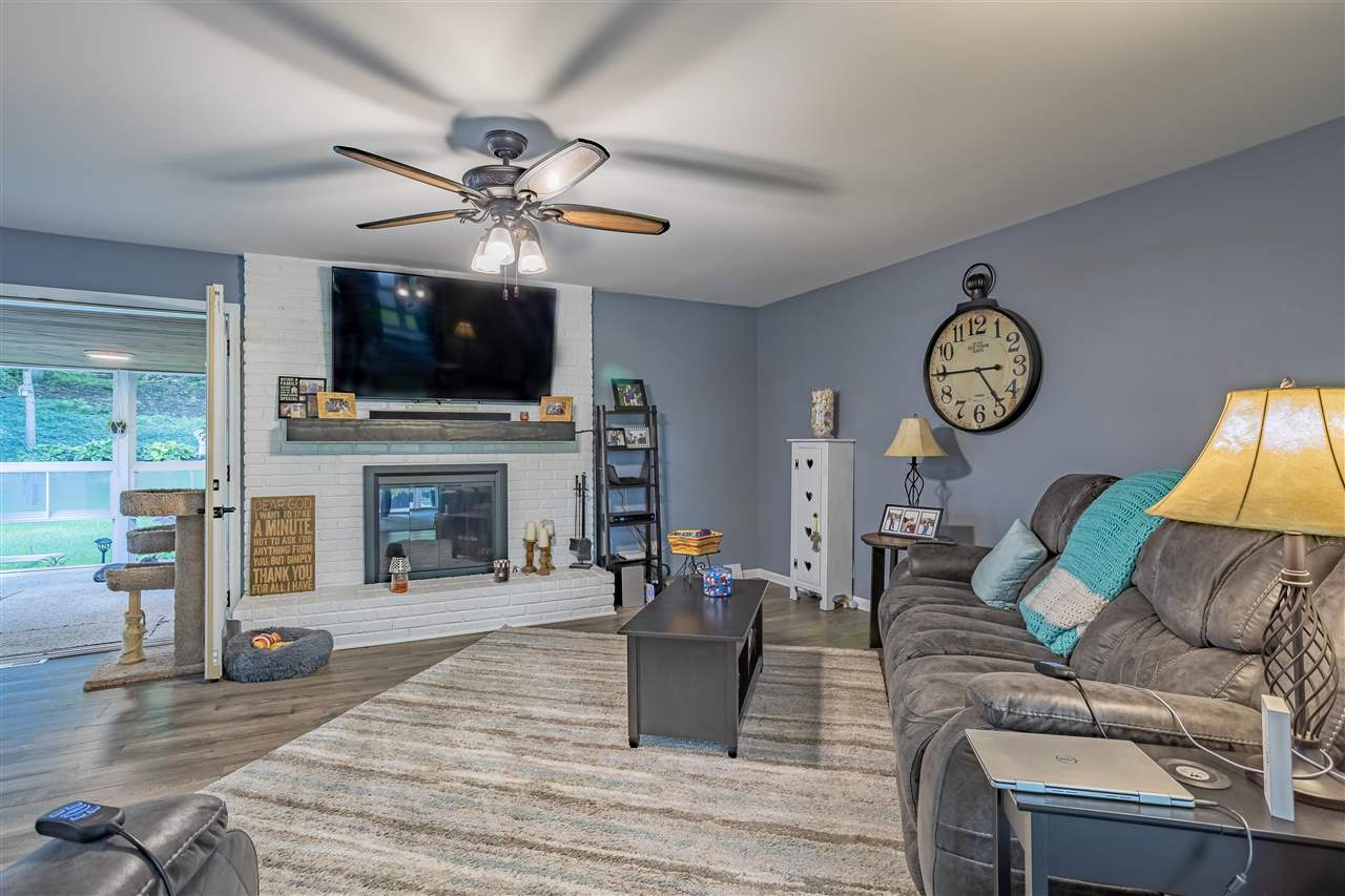 3208 Spring Creek Road Rockford, IL 61107 - Photo 15 of 45 a living room with furniture a fireplace and a flat screen tv