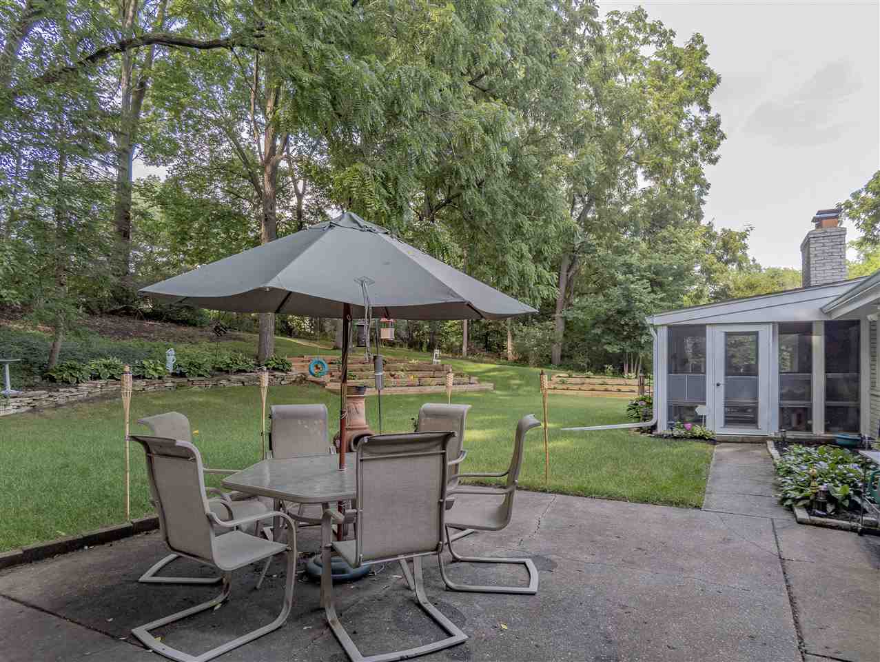 3208 Spring Creek Road Rockford, IL 61107 - Photo 35 of 45 a view of a patio with chairs and table under an umbrella