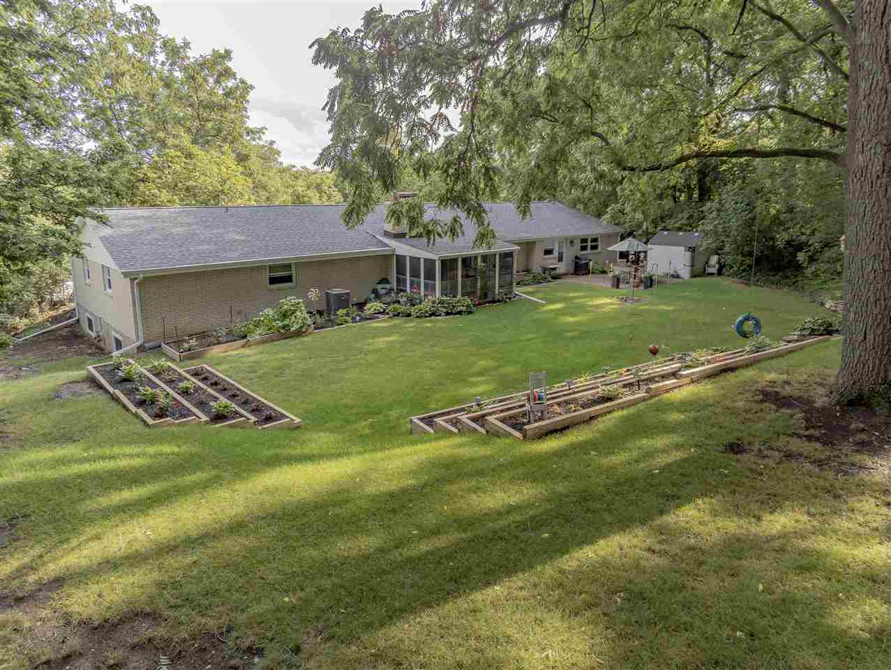 3208 Spring Creek Road Rockford, IL 61107 - Photo 40 of 45 a view of a house with a big yard and large trees