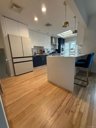 a kitchen with stainless steel appliances granite countertop a refrigerator a stove and a wooden floors