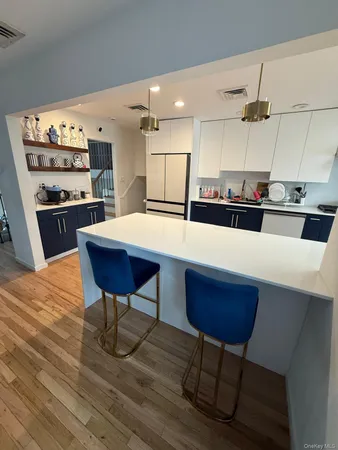 a kitchen with stainless steel appliances kitchen island granite countertop a table chairs stove and refrigerator