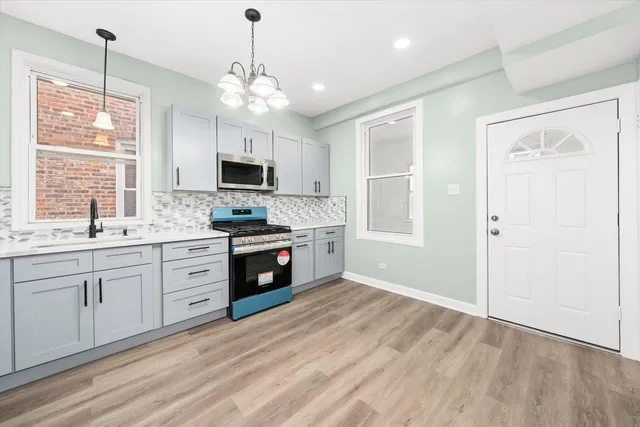 a kitchen with granite countertop a stove a sink and a refrigerator