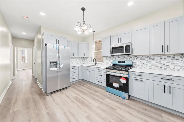 a kitchen with stainless steel appliances a stove refrigerator sink and microwave