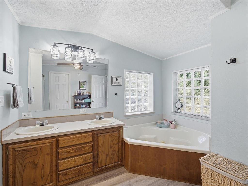 3275 Finis Road Graham, TX 76450 - Photo 18 of 36 a spacious bathroom with a sink double vanity granite tub shower and a mirror