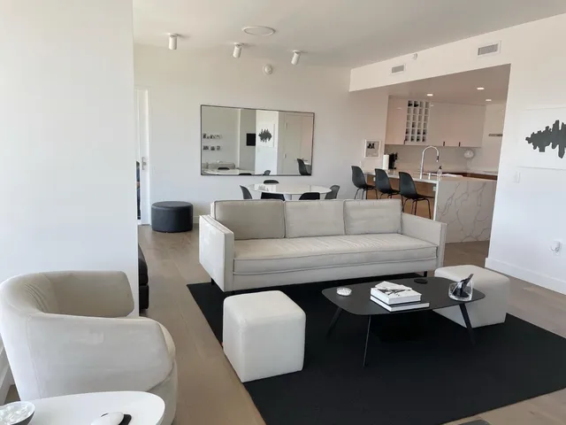 a living room with furniture and a view of kitchen