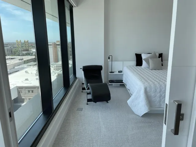 a bedroom with furniture and a large window