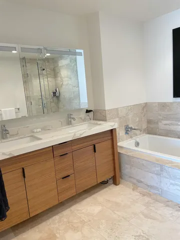 a spacious bathroom with a tub sink and mirror
