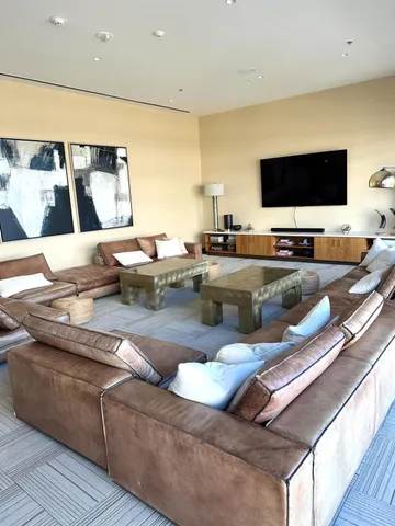 a living room with stainless steel appliances furniture and a flat screen tv