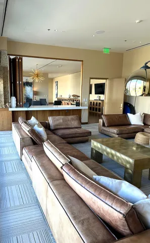 a living room with stainless steel appliances granite countertop furniture and a wooden floor