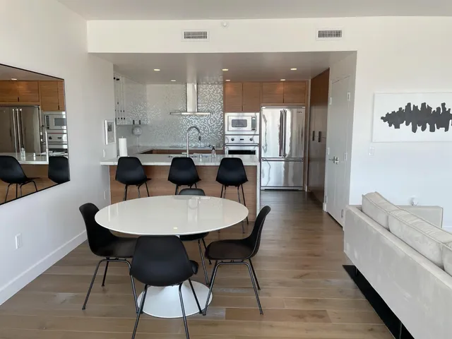 a large kitchen with dining table space and stainless steel appliances