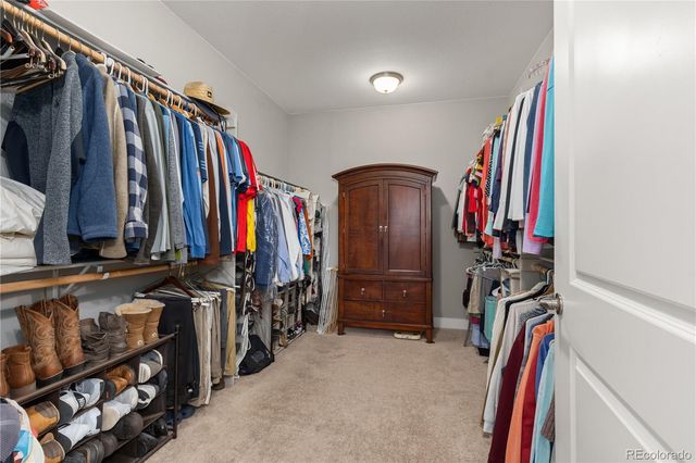 a view of walk in closet with clothes