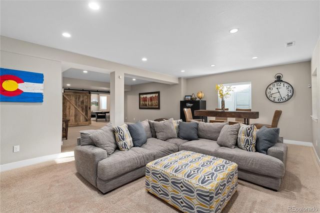 a living room with furniture a rug and a window
