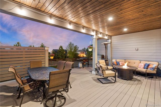 a view of a patio with dining table and chairs with wooden floor and fence