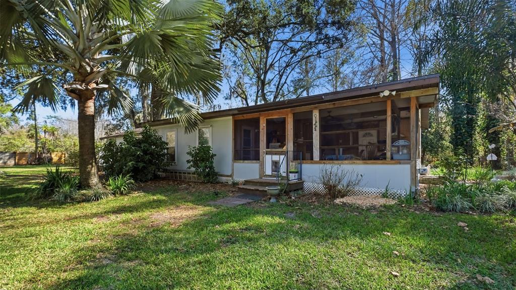 10565 Bessemer Street New Port Richey, FL 34654 - Photo 33 of 72 a view of house in front of a yard with potted plants and large trees